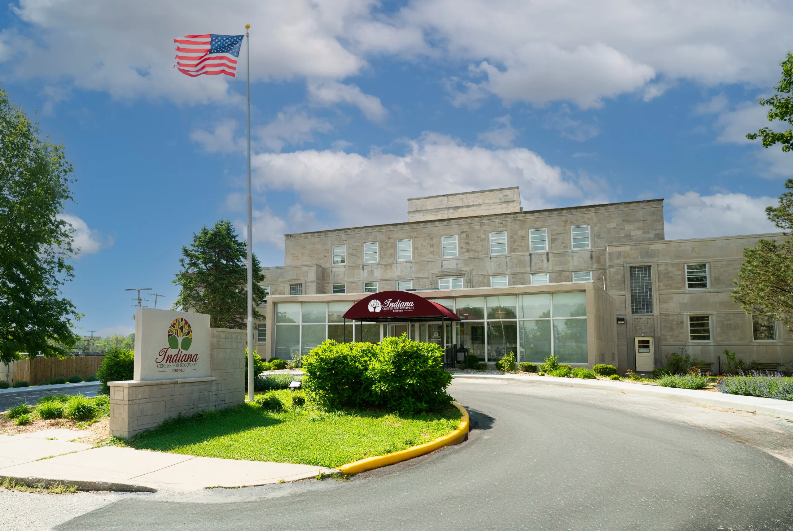 Rehab facility exterior with U.S. flag and main entrance.