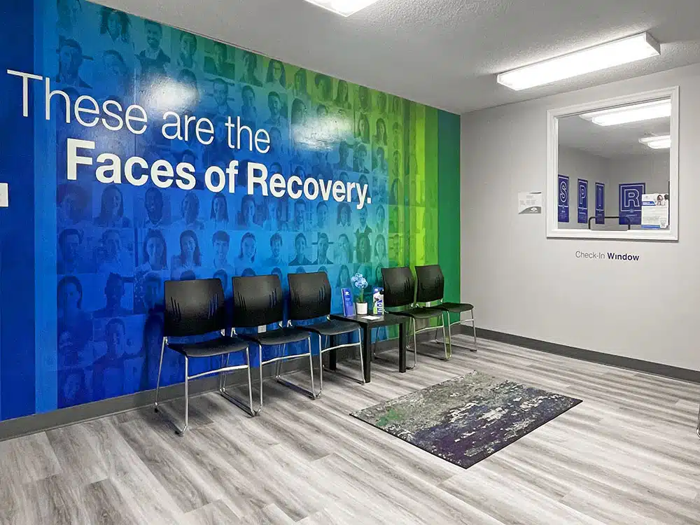 Waiting area with chairs and Faces of Recovery mural wall
