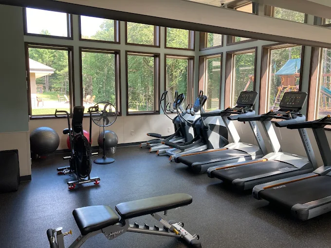 Gym with treadmills, bikes, and windows overlooking outdoors