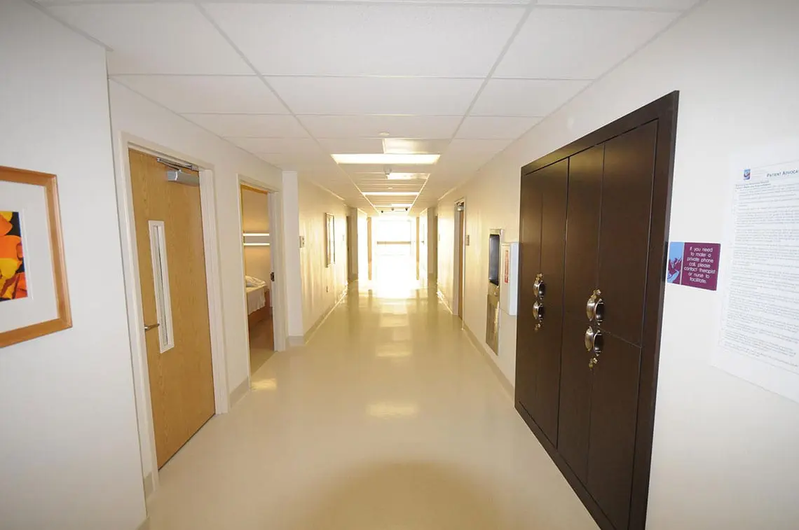 Clean hallway with patient rooms and bright lighting
