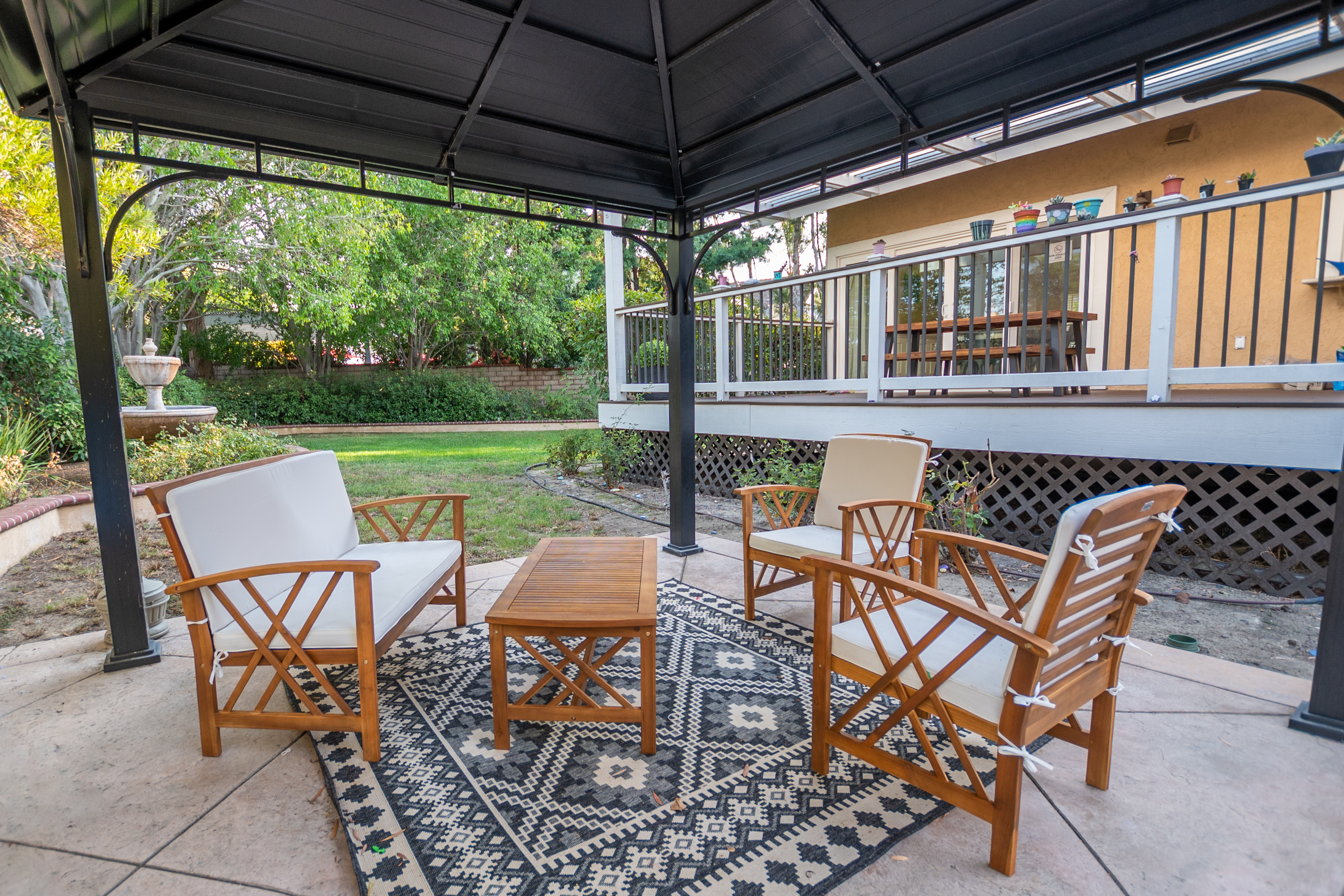 Outdoor seating area under gazebo in garden