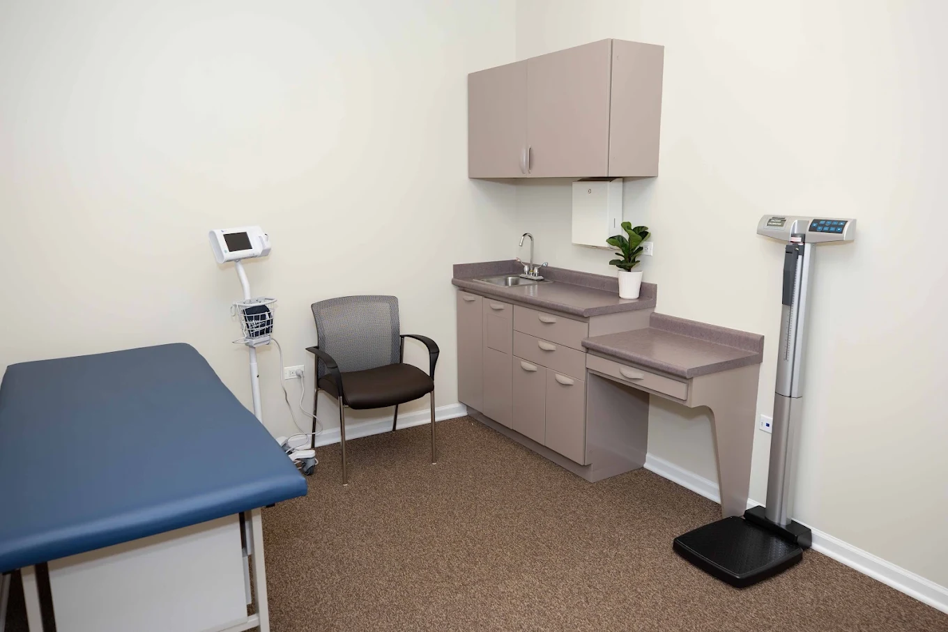 Exam room with treatment table, medical scale, and cabinets