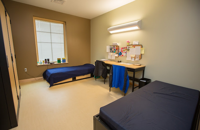 Bedroom with two twin beds and desks along wall