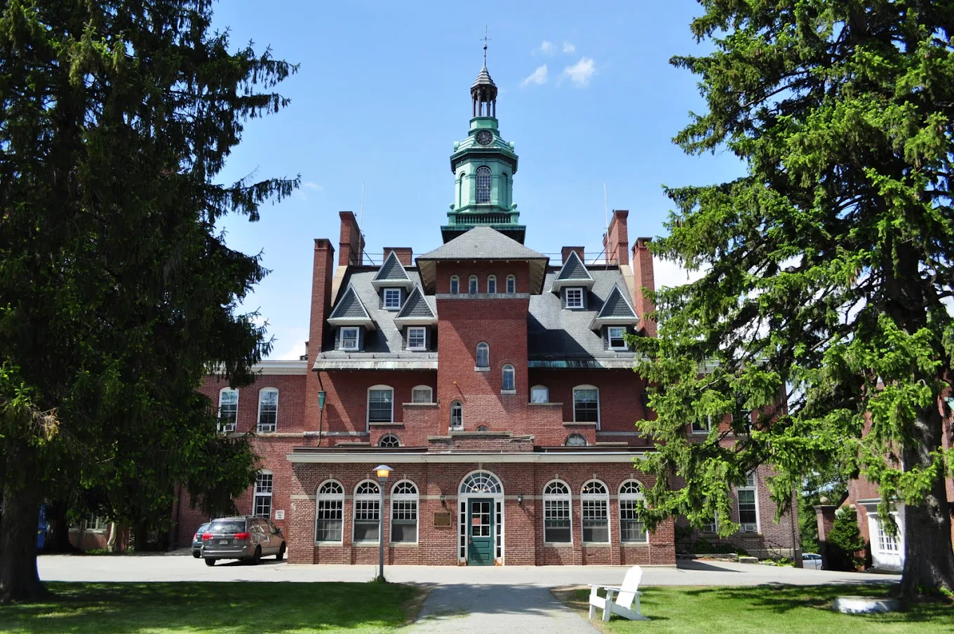 Historic brick treatment building with clock tower and green dome