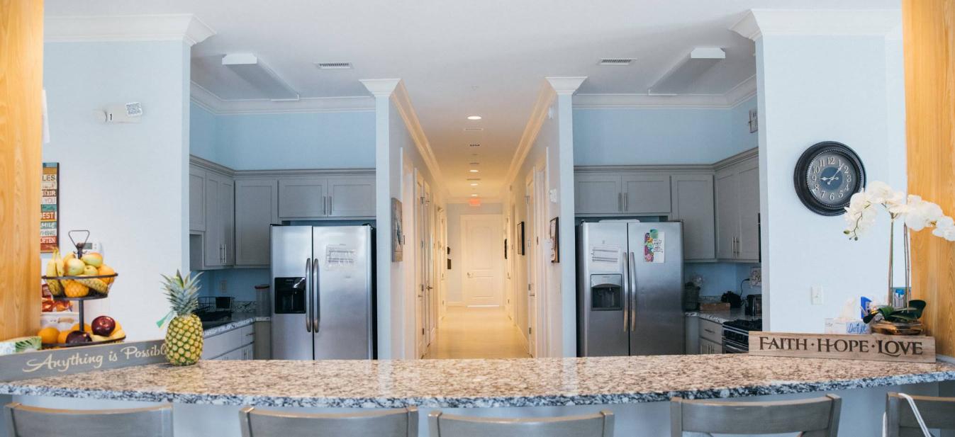 Bright communal kitchen with island seating and appliances
