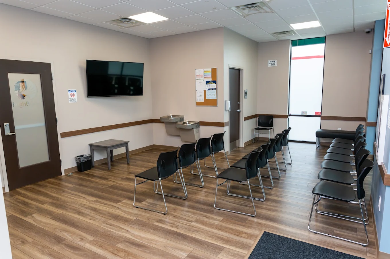 BrightView Danville lobby with rows of black chairs, television, drinking fountains, and wood-look flooring