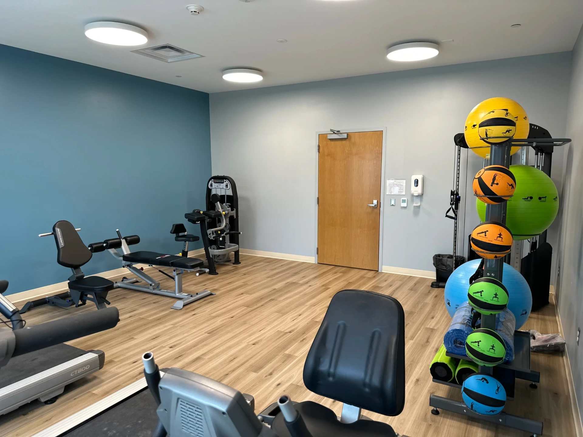 Fitness room with cardio equipment and exercise tools.