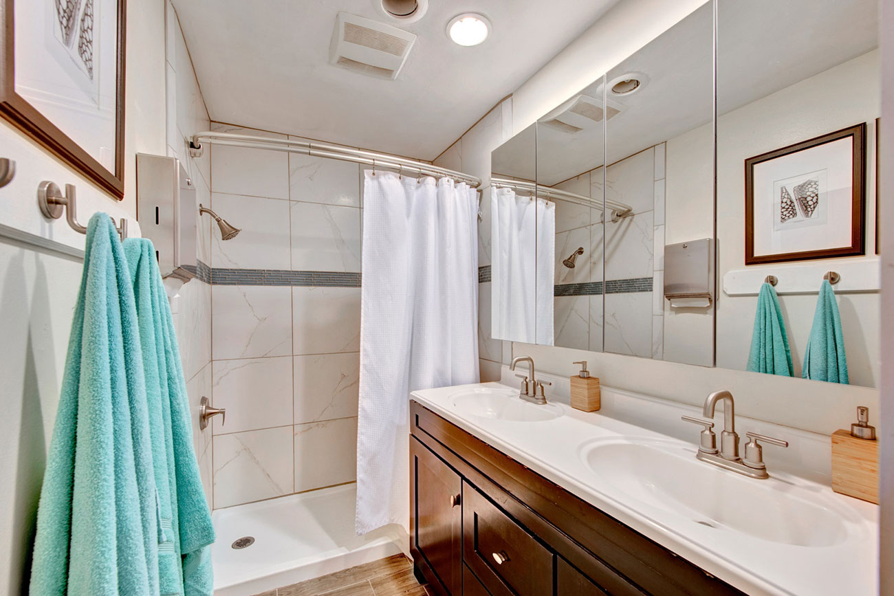 Modern bathroom with double sinks and shower.