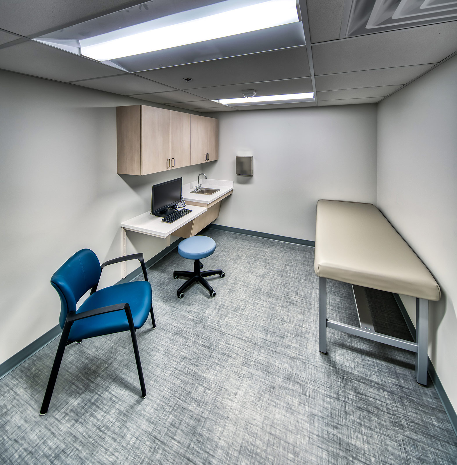 Clean exam room with desk and exam table