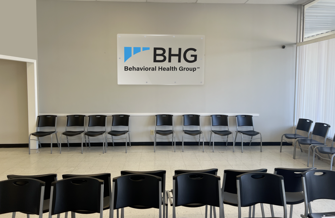 Lobby seating area with chairs beneath facility sign