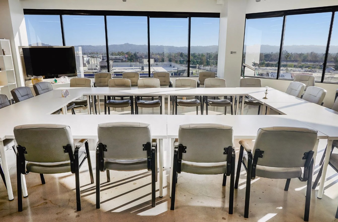 Spacious group therapy room with U-shaped seating and floor-to-ceiling windows