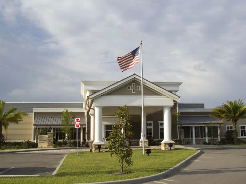 Front building view with flagpole and landscaped drive