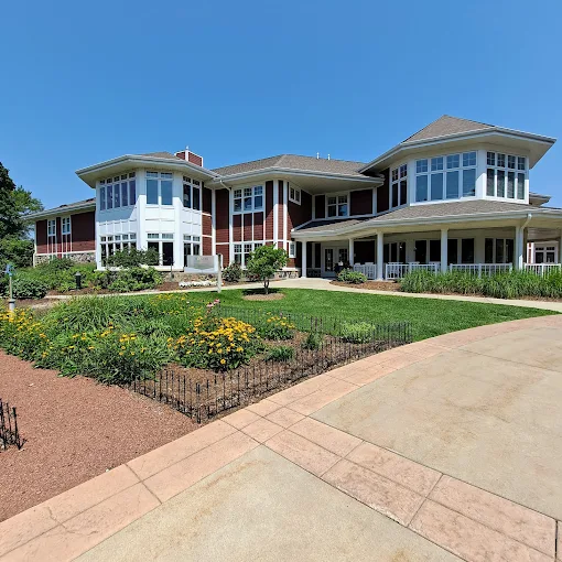 Large red and white treatment center building with gardens