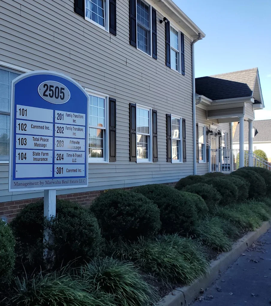 Building directory sign beside landscaped facility exterior