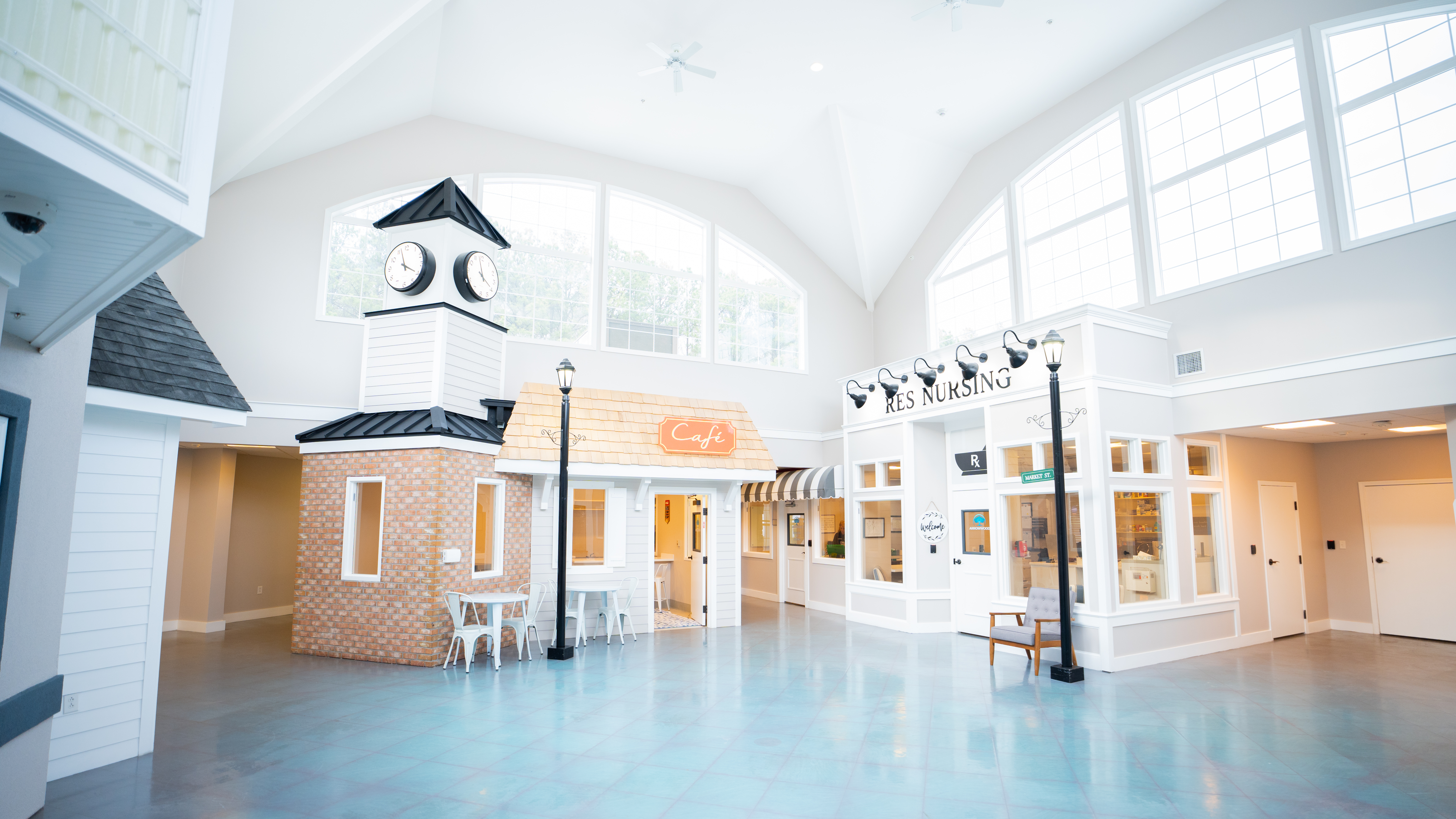 Bright indoor common area with café and mock storefronts