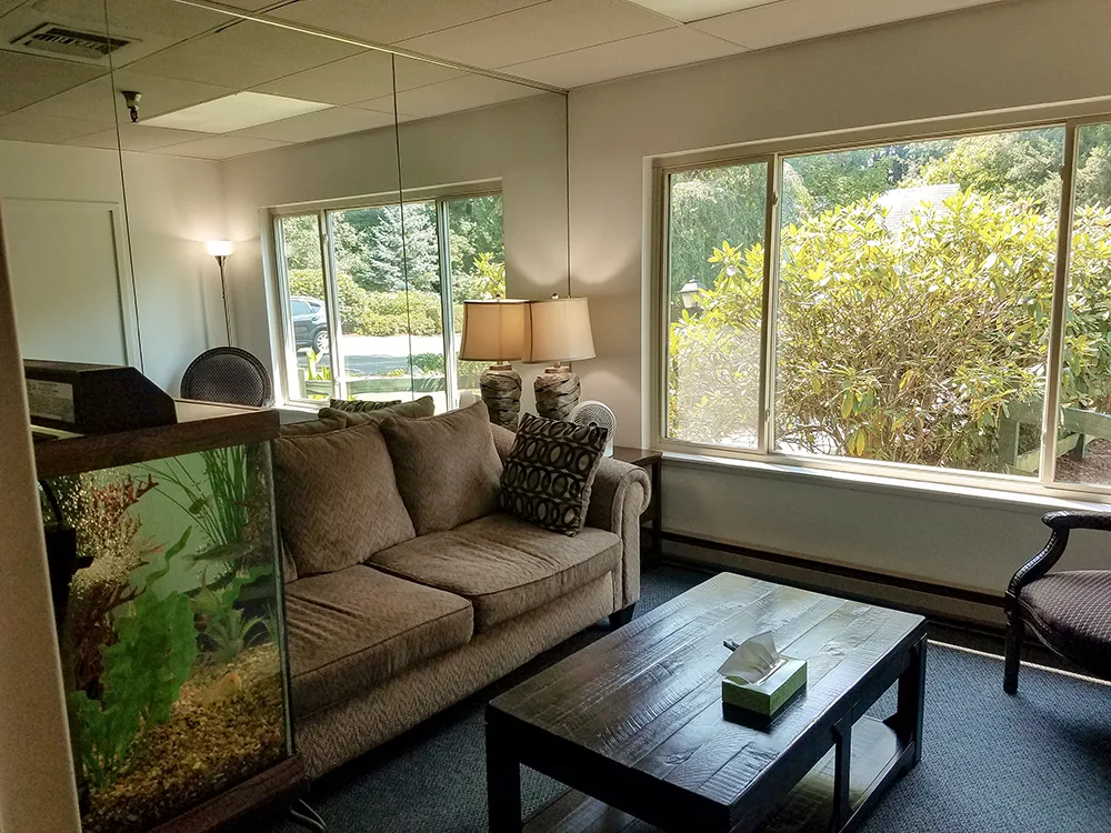 Cozy living room with sofa, chairs, and large windows