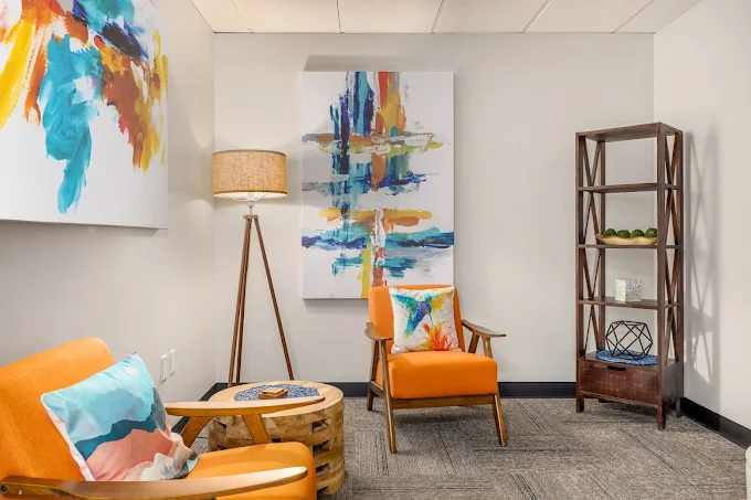 Cozy therapy room with bright chairs and abstract artwork