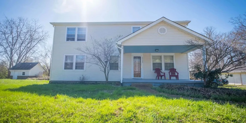 White two-story house with a front porch.