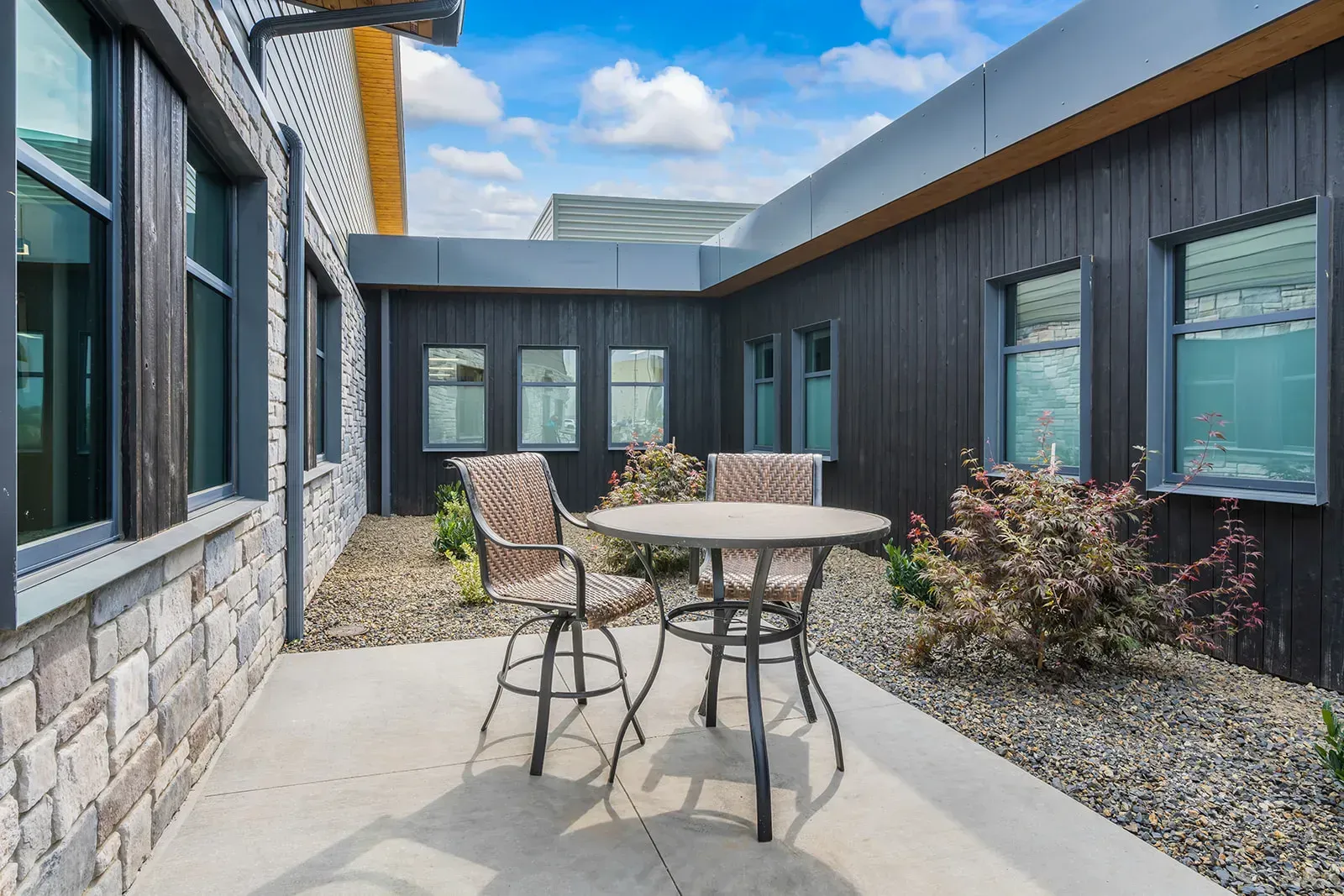 Private outdoor patio with table and chairs between buildings
