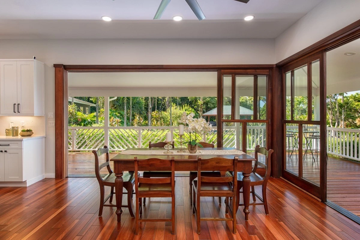 Dining table by large windows and tropical view