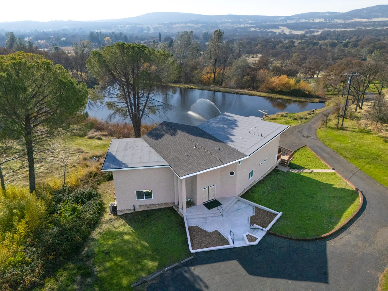 Aerial shot of facility beside pond and trees