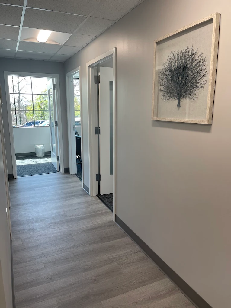 Bright hallway with doors and framed wall art
