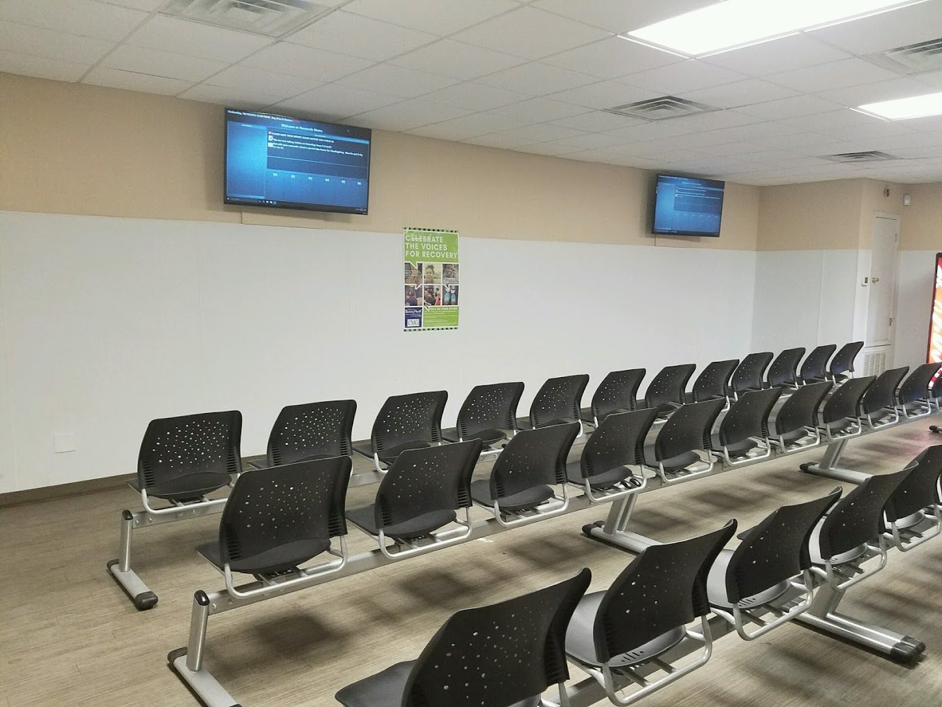 Waiting area with chairs in rows and TV's.