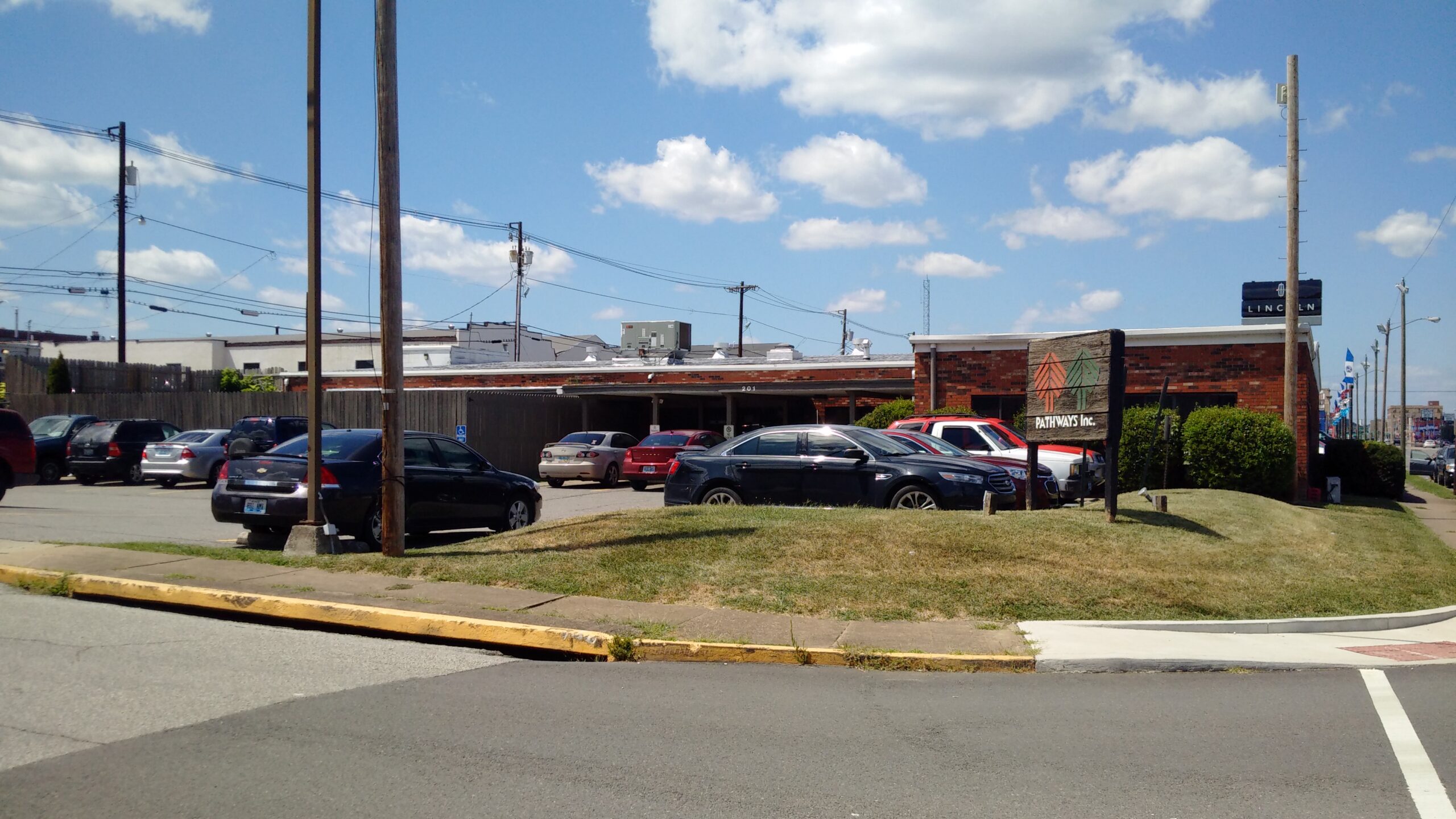 Brick rehab facility with parking lot and wooden Pathways sign
