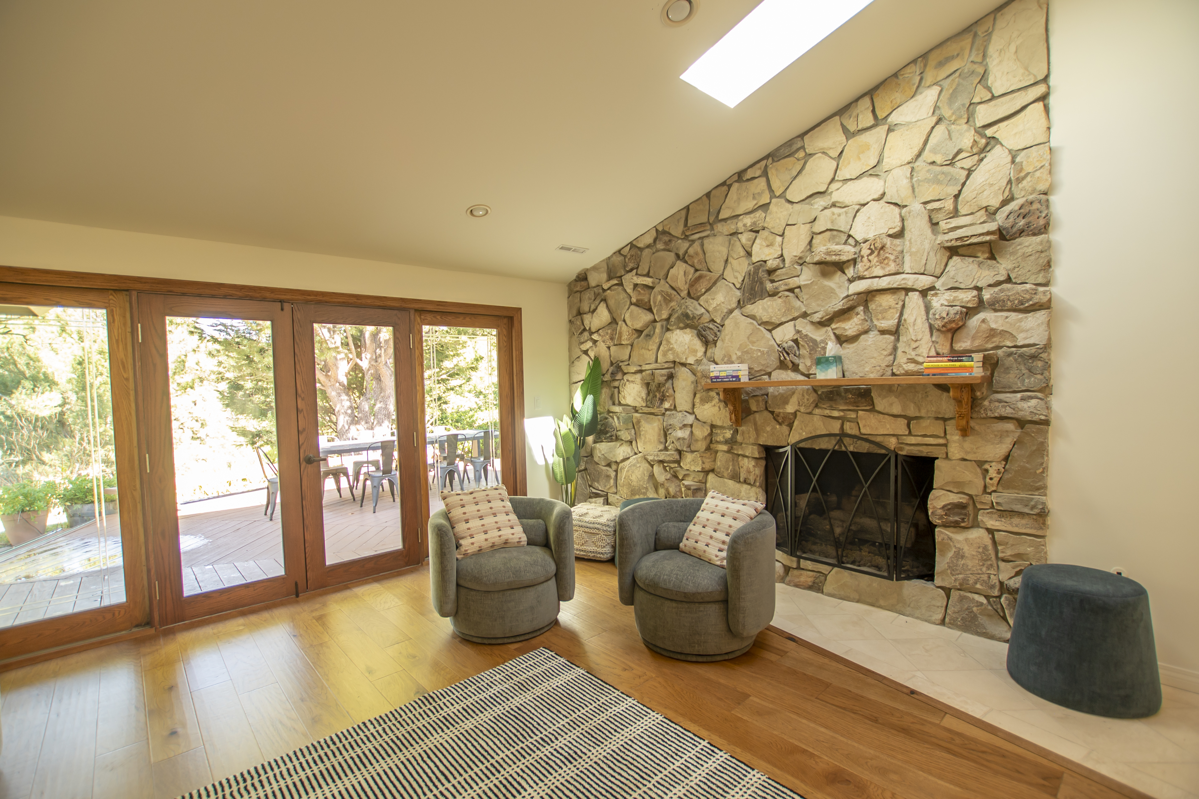 Stone fireplace with two chairs and natural light