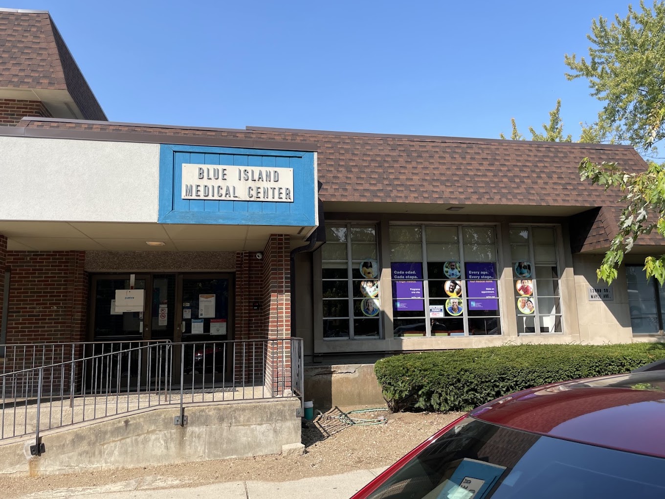 Brick building entrance with sign and window posters
