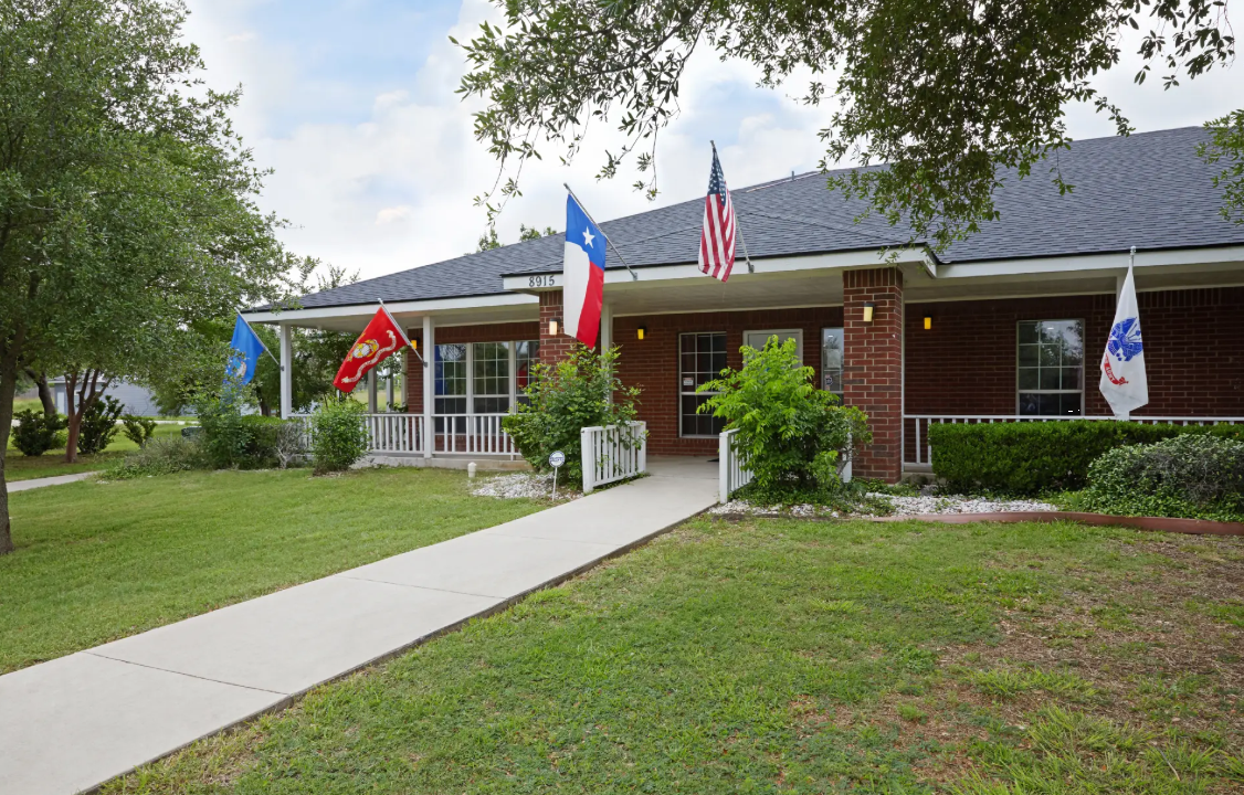 Brick rehab center with flags and front porch