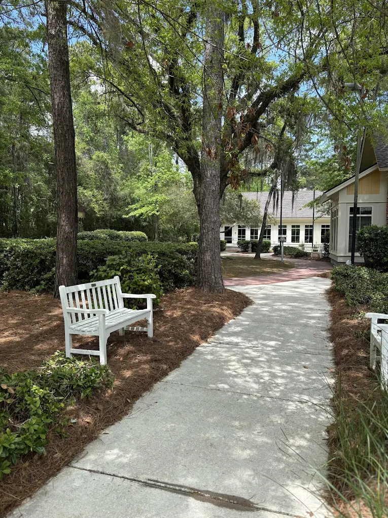 Shaded walking path with benches and landscaped grounds