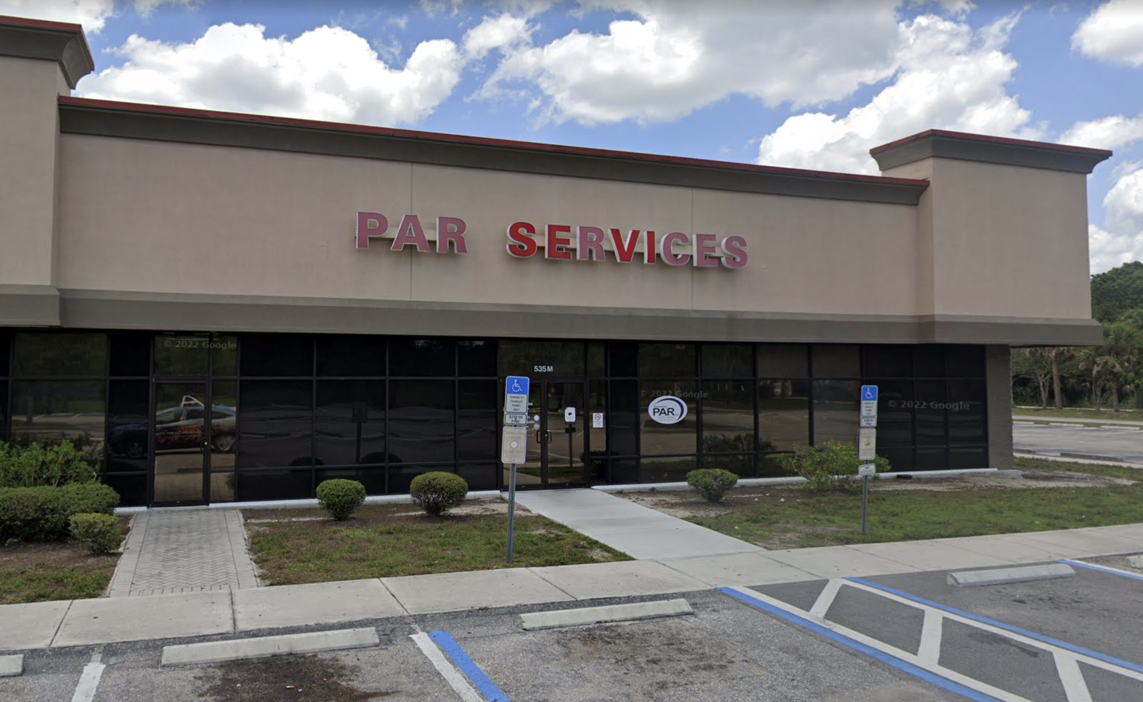 Beige PAR Services building with glass windows and parking spaces