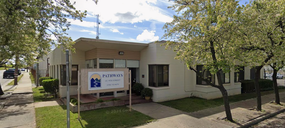 Single-story Pathways rehab building with sign, trees, and front walkway