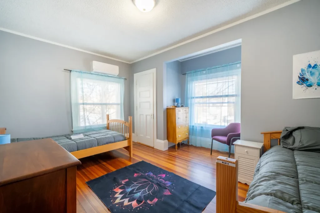 Shared bedroom with two twin beds and hardwood floors