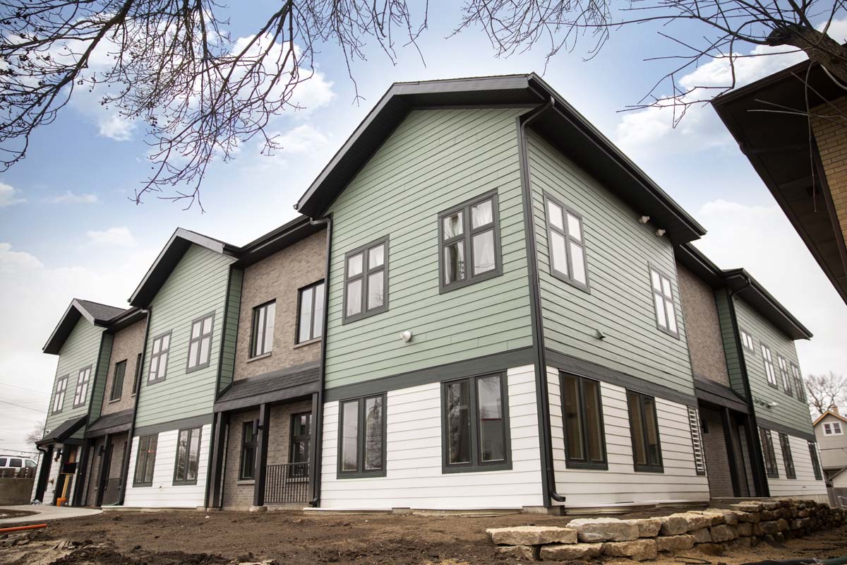 Modern two-story building with green siding and large windows