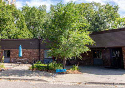 Front entrance of facility with brick exterior and trees