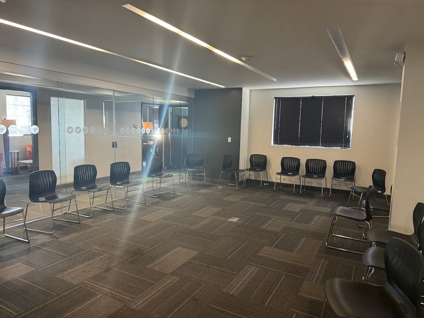 Large group therapy room with black chairs arranged in a circle.