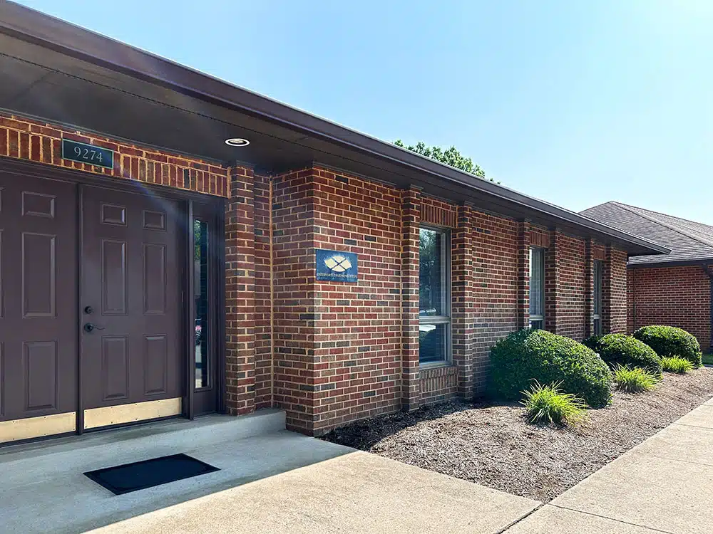 Exterior entrance of brick rehab facility with signage