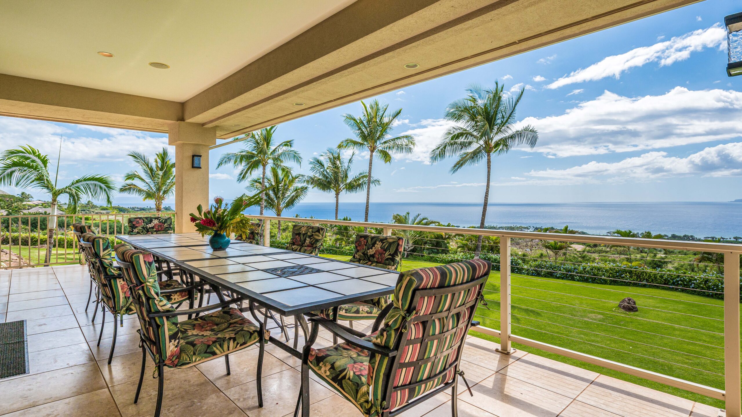 Covered outdoor dining area with panoramic ocean views and seating for group meals