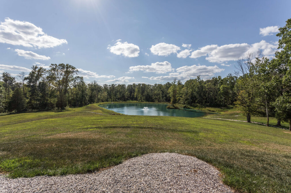 Grassy backyard with pond and trees at NewDay Center