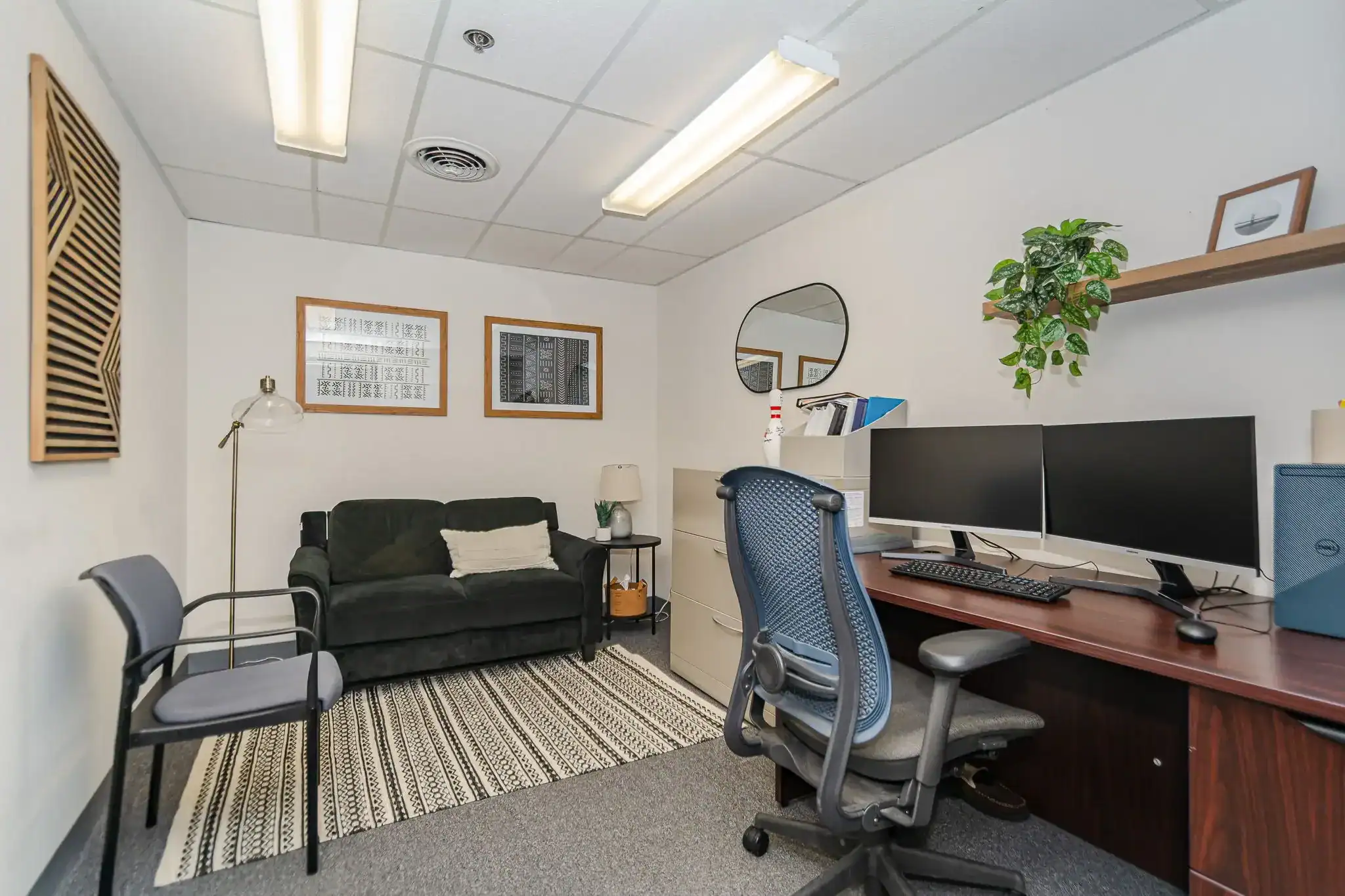Counselor office with desk, sofa, and guest chair