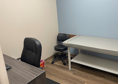 Exam room with patient chair, desk, and examination table