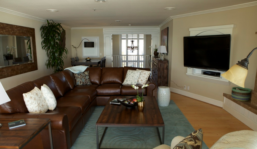 Cozy living room with a leather sectional and mounted TV.