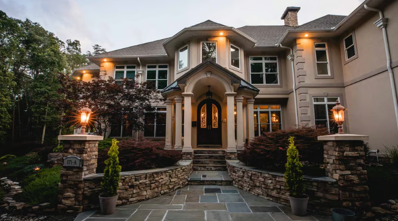 Elegant two-story home with stone entryway and porch lighting