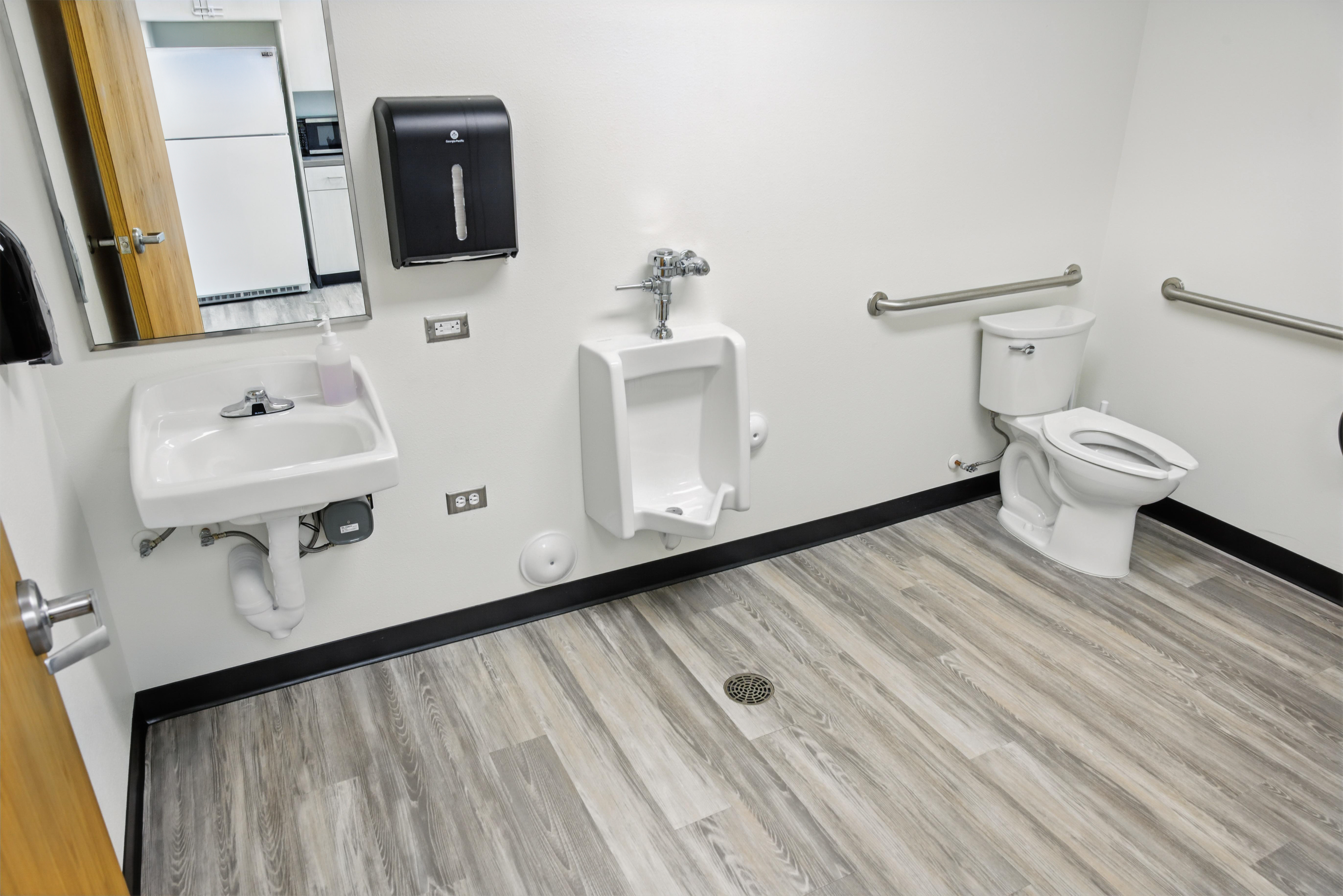 Clean restroom with sink, urinal, and toilet