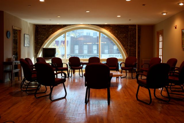 Group therapy room with circle of chairs and large window
