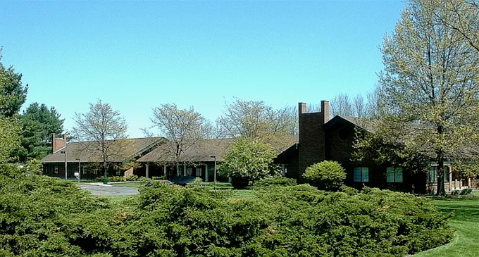 Rehab facility exterior surrounded by trees and shrubs