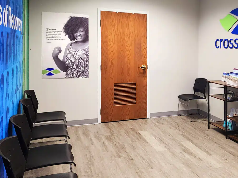 Waiting room with chairs, posters, and wood door