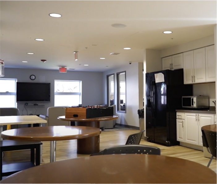 Common room with kitchen area, tables, and foosball table